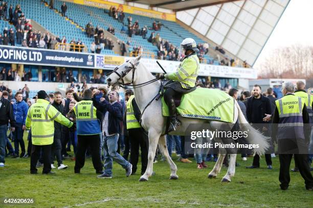 Police have to step in to control the Millwall fans on the pitch after The Emirates FA Cup Fifth Round tie between Millwall and Leicester City at The...