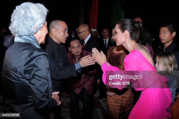 Hollywood star Angelina Jolie pays respect to Cambodian King Norodom Sihamoni as former queen Monique looks on during the premiere of Jolie's new...