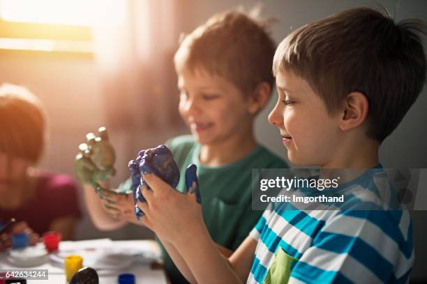 children having fun painting easter eggs - finger painting stock pictures, royalty-free photos & images