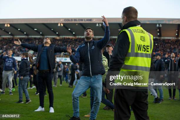 Millwall fans celebrate their victory by invading the pitch at full time and taunting the away fans during the Emirates FA Cup Fifth Round match...