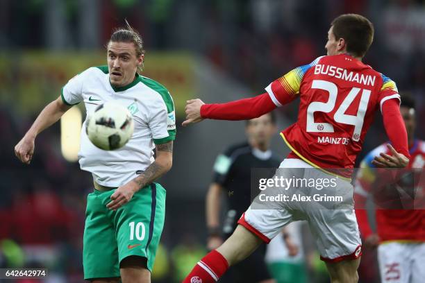 Max Kruse of Bremen is challenged by Gaetan Bussmann of Mainz during the Bundesliga match between 1. FSV Mainz 05 and Werder Bremen at Opel Arena on...