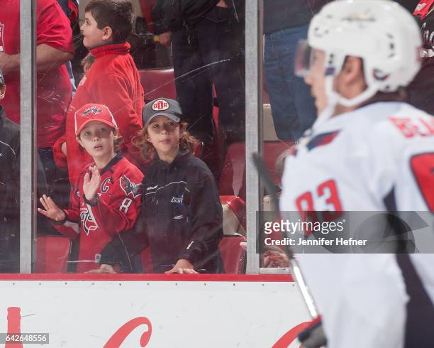 Fans watch Jay Beagle of the Washington Capitals skate in warm-ups prior to an NHL game against the Detroit Red Wings at Joe Louis Arena on February...