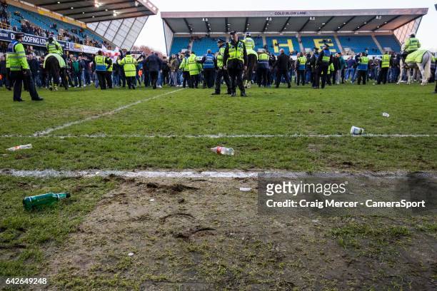 Debris of coins and bottles are seen on the pitch having been thrown onto the field after Millwall fans staged a pitch invasion at full time during...