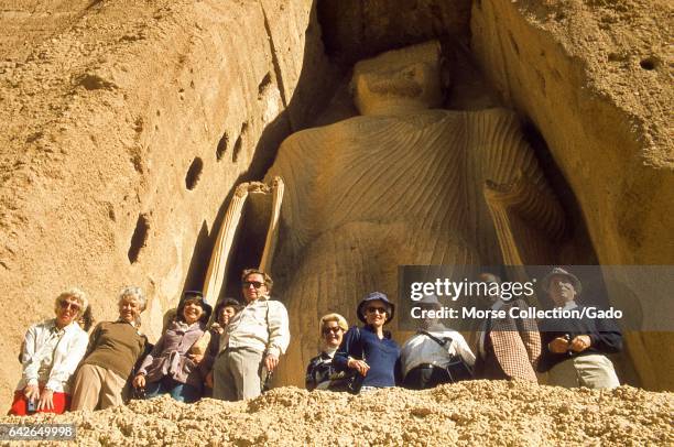 View of Western tourists posing before the massive height of the smaller giant Buddha, known as Shamama, in Bamiyan, Hazarajat region, central...