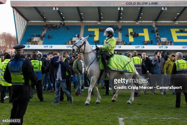 Police horses called in to help calm the pitch invasion by Millwall fans during the Emirates FA Cup Fifth Round match between Millwall v Leicester...