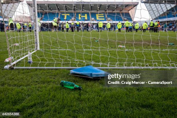 Debris of coins and bottles and a broken seat are seen on the pitch having been thrown onto the field after Millwall fans staged a pitch invasion at...