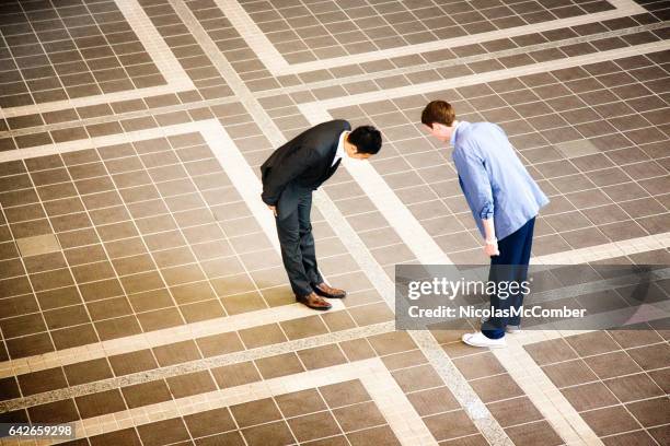 two businessmen meeting in japan and bowing - humble beginnings stock pictures, royalty-free photos & images