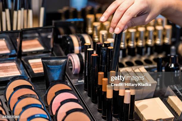 woman's hand choosing make-up - magasin cosmétique photos et images de collection