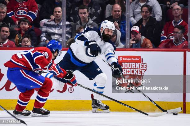 Mark Stuart of the Winnipeg Jets looks to play the puck past Brian Flynn of the Montreal Canadiens during the NHL game at the Bell Centre on February...