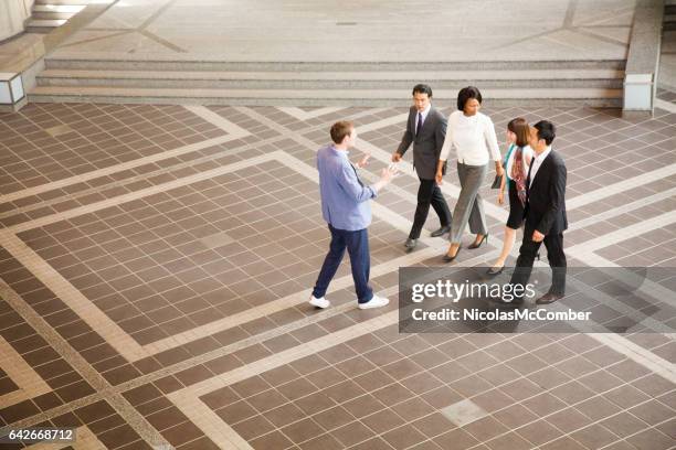 team leader leading multi-ethnic group while explaining - free trade hall stock pictures, royalty-free photos & images