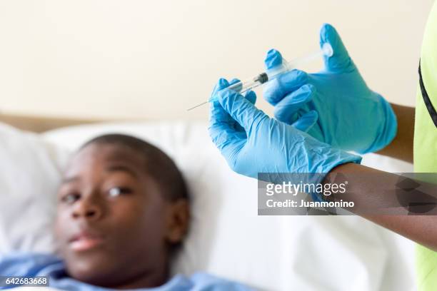 十幾歲的男孩在等待醫生的射門 - ebola liberia 個照片及圖片檔