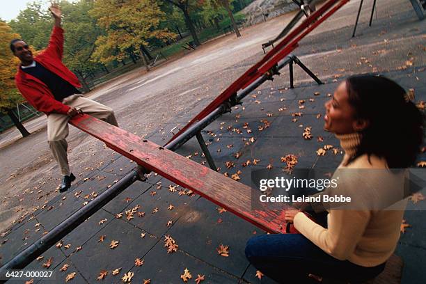 couple on seesaw - seesaw stock pictures, royalty-free photos & images