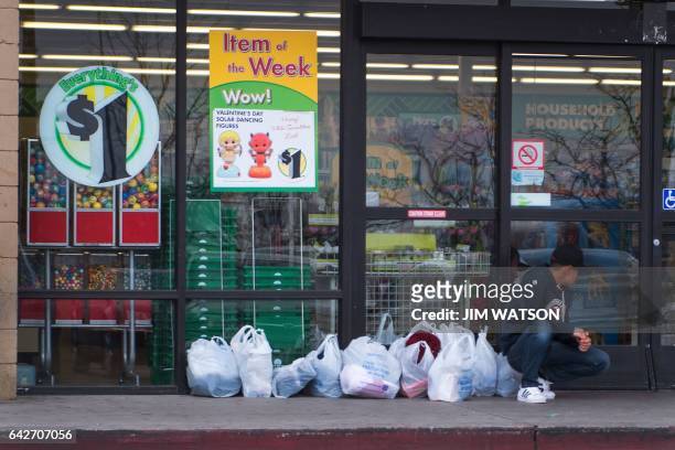 Boy guards his family's shopping bags from Walmart as they continue shopping inside a dollar store in Douglas, Arizona, on February 18 on the...