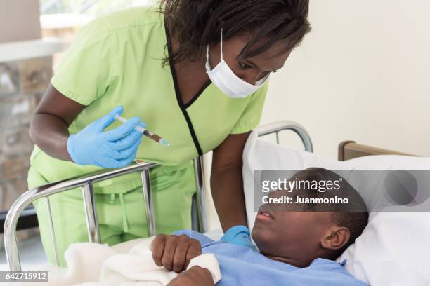 female nurse trying to vaccinate a terrified boy - ebola hospital stock pictures, royalty-free photos & images