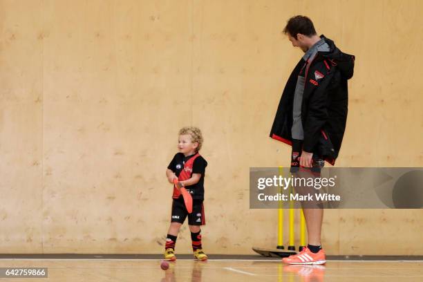 Jobe Watson plays some cricket with a little kid on his way to get changed during the Essendon Bombers AFL Family Day at Essendon Football Club on...