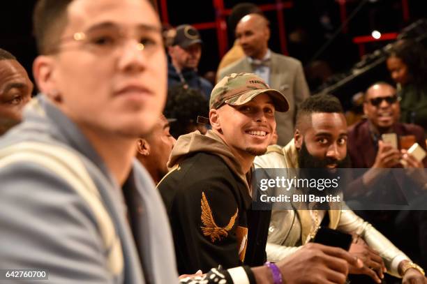 Devin Booker of the Phoenix Suns, Stephen Curry of the Golden State Warriors and James Harden of the Houston Rockets sit courtside during the JBL...