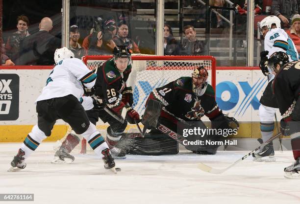 Michael Stone of the Arizona Coyotes knocks the puck away from David Schlemko of the San Jose Sharks as he skates in on goalie Mike Smith of the...