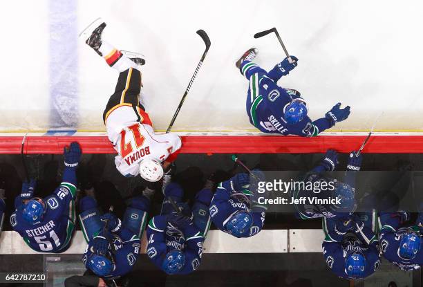 Jack Skille of the Vancouver Canucks and Lance Bouma of the Calgary Flames skate past the Vancouver bench during their NHL game at Rogers Arena...