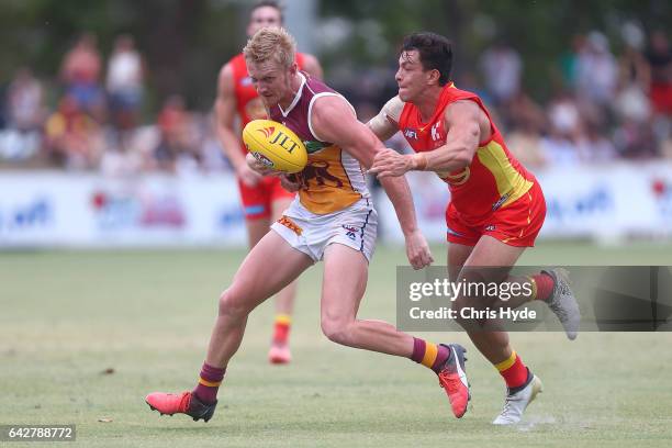 Nick Robertson of the Lions is tackled by Jesse Lonergan of the Suns during the 2017 JLT Community Series match at Broadbeach Sports Centre on...