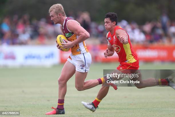 Nick Robertson of the Lions is tackled by Jesse Lonergan of the Suns during the 2017 JLT Community Series match at Broadbeach Sports Centre on...