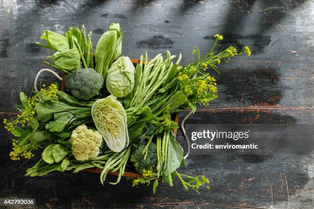 fresh green leaf vegetables in an old wooden crate on an old wooden table. - legume-de-folhas imagens e fotografias de stock
