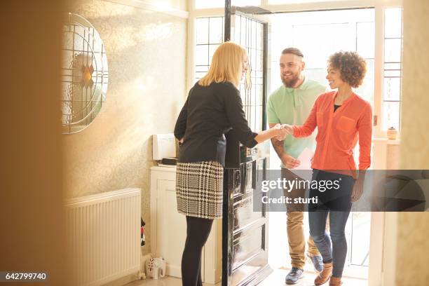 estate agent welcoming a couple to house viewing - perfect home stock pictures, royalty-free photos & images