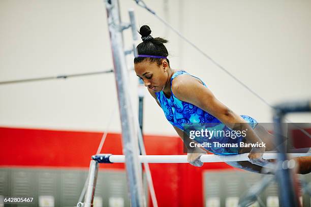 female gymnast on bar during training session - gymnastics stock pictures, royalty-free photos & images