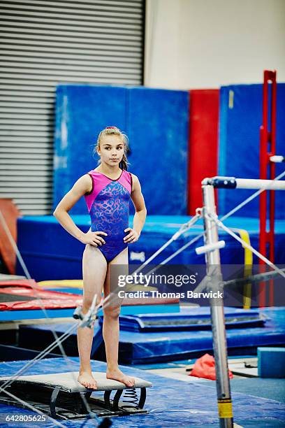 Female gymnast resting between bar exercises