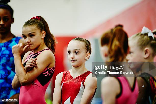 gymnast waiting with teammates before workout - leotard stockfoto's en -beelden