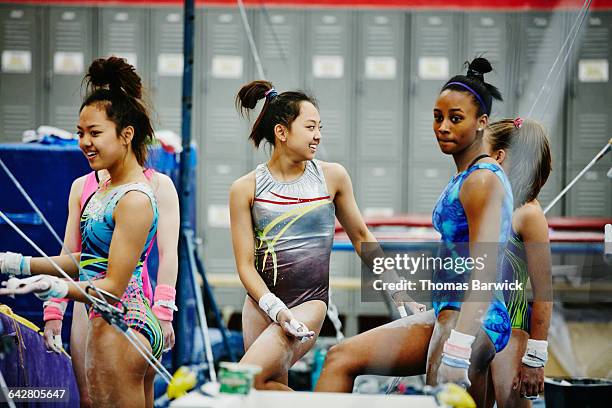 smiling gymnasts waiting to practice on bars - gymnastic asian stockfoto's en -beelden