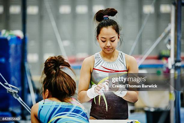 gymnast chalking hands before practicing on bars - gymnastics championships day 2 stock pictures, royalty-free photos & images