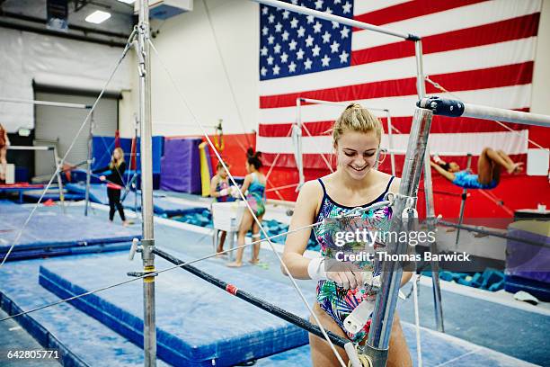 gymnast adjusting bar grips before bar exercises - floor gymnastics stock pictures, royalty-free photos & images