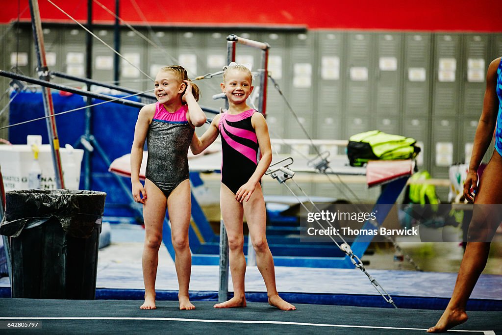 Gymnasts watching teammates perform floor routine