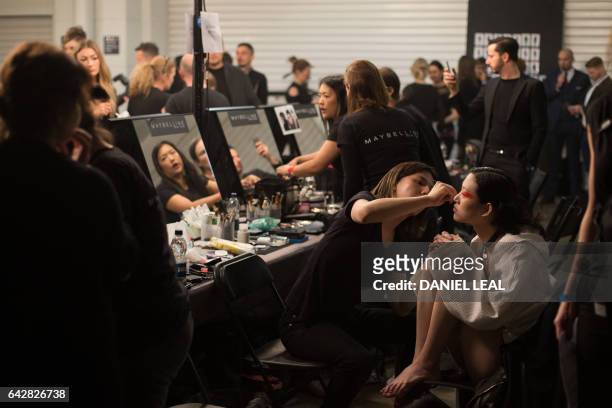 Models are prepared backstage before the Versus catwalk show on the second day of the Autumn/Winter 2017 London Fashion Week in London on February...