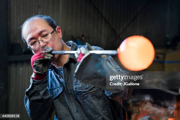 glassblower shaping molten glass - glass blowing stock pictures, royalty-free photos & images