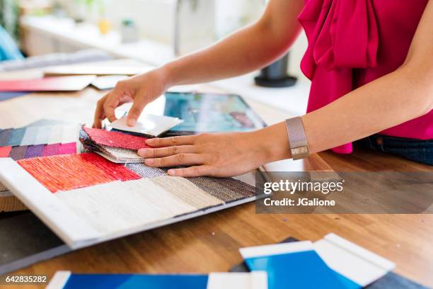 designer looking at colour swatches - fabric swatches imagens e fotografias de stock