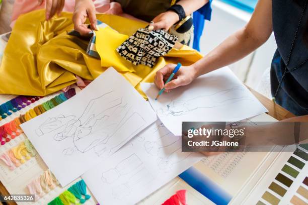 overhead view of a team of fashion designers working - fashion designer sewing stock pictures, royalty-free photos & images