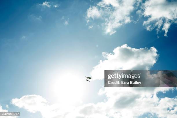 hand glider flying across sun and clouds - hang glider stock pictures, royalty-free photos & images
