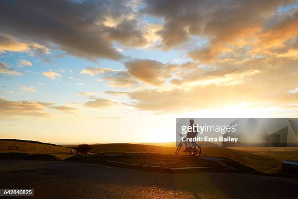 mountain biker admiring the view from hilltop - morning stock pictures, royalty-free photos & images