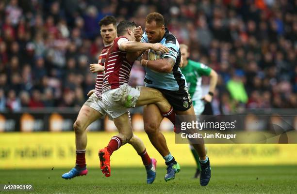 Sam Tagataese of Cronulla-Sutherland Sharks is tackled by Morgan Escare of Wigan Warriors during the Dacia World Club Challenge match between Wigan...