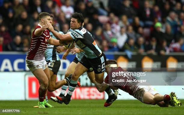 Chad Townsend of Cronulla-Sutherland Sharks is tackled by Sam Powell of Wigan Warriors during the Dacia World Club Challenge match between Wigan...