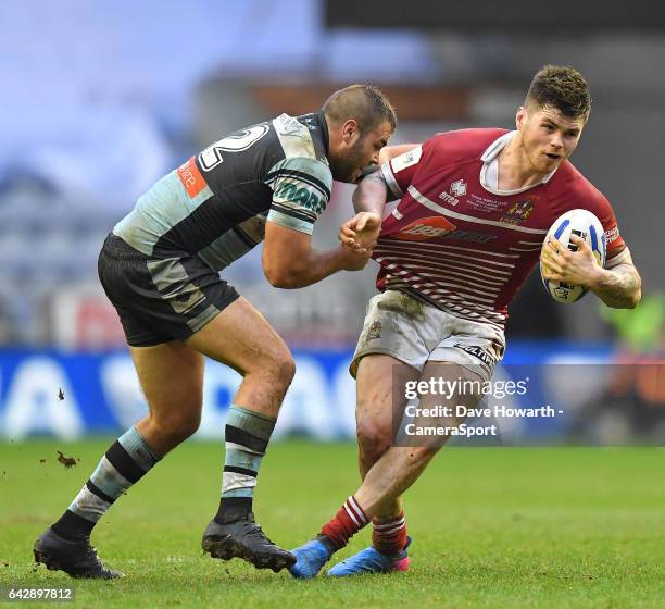 Wigan Warriors' John Bateman is tackled by Cronulla-Sutherland Sharks' Wade Graham during the Dacia World Club Challenge match between Wigan Warriors...