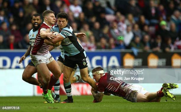 Chad Townsend of Cronulla-Sutherland Sharks is tackled by Sam Powell of Wigan Warriors during the Dacia World Club Challenge match between Wigan...