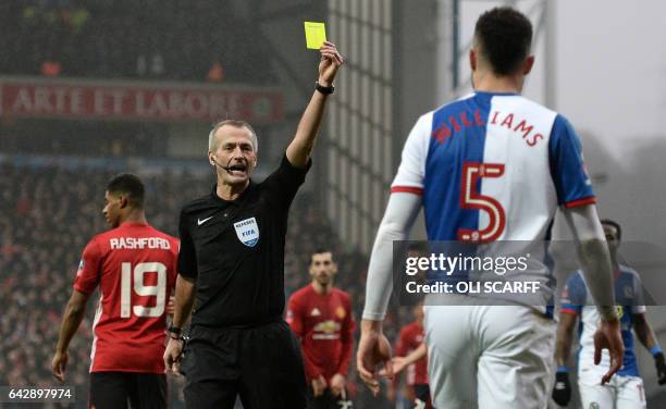 Blackburn Rovers' Irish defender Derrick Williams receives a yellow card during the English FA Cup fifth round football match between Blackburn...