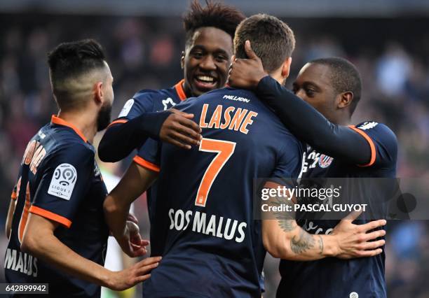 Montpellier's French midfielder Paul Lasne is congratulated by teammates after scoring a goal during the French L1 football match between MHSC...