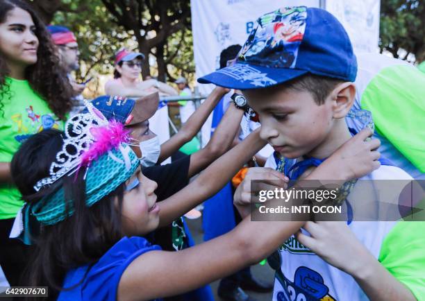 Children receive medals from children with cancer, after completing the "5K Heroes with True Battles" walk, in Managua on February 19, 2017. People...