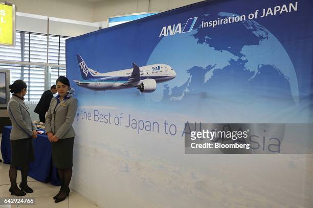 All Nippon Airways Co. Flight attendants stand next to a banner during the company's media event at Benito Juarez International Airport in Mexico...