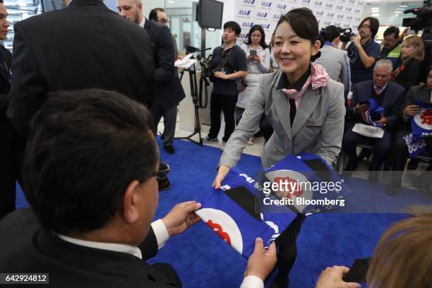 An All Nippon Airways Co. Employee hands out kimono shirts during the company's media event at Benito Juarez International Airport in Mexico City,...
