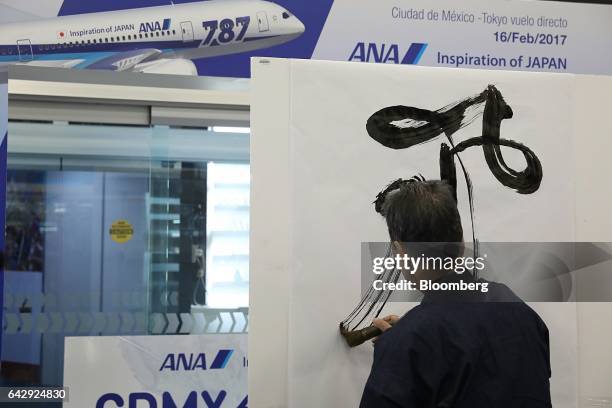 Japanese calligraphy artist paints during an All Nippon Airways Co. Media event at Benito Juarez International Airport in Mexico City, Mexico on...