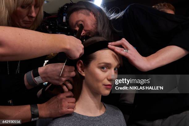 Model is prepared backstage before a catwalk show for British fashion label Temperley London on the third day of the Autumn/Winter 2017 London...
